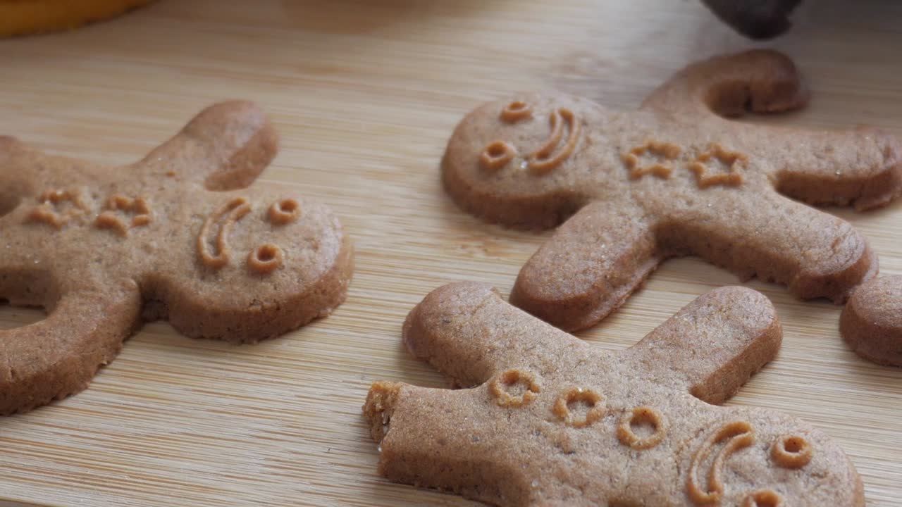 Close-up of gingerbread men cookies on a table. One broken