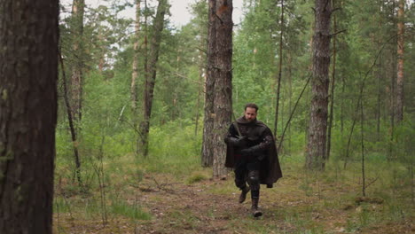 medieval warrior with cape and large sword runs across wood