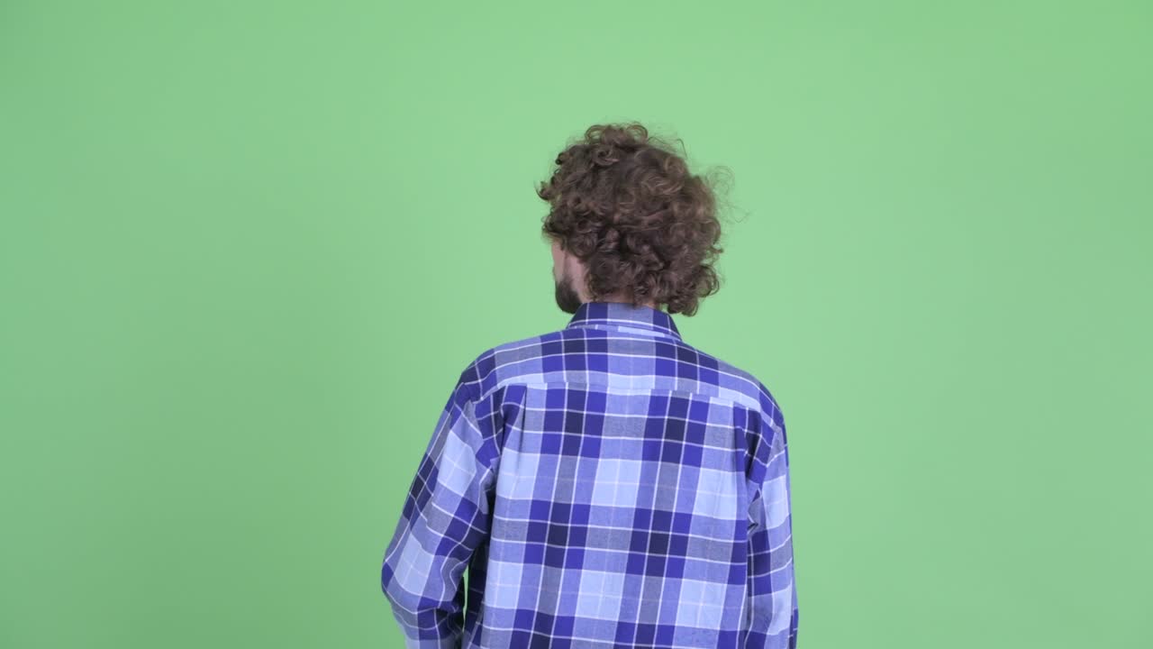 Young handsome bearded hipster man with curly hair