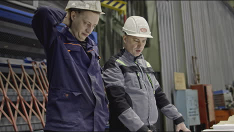 factory workers reviewing plans