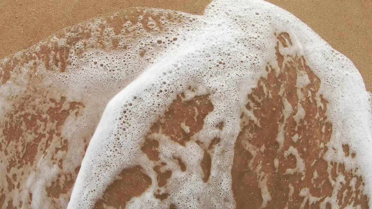 фруктовые надписи на теплом песке смывают морскую воду в солнечный день.