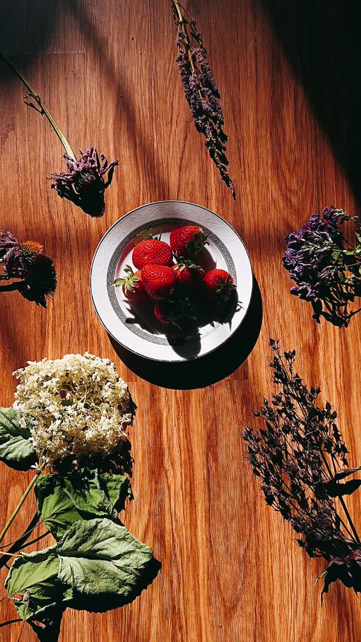 fresas y flores en una mesa de madera