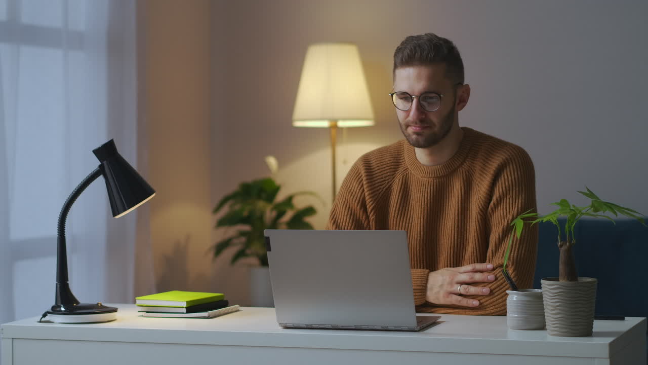 retrato de um participante masculino de um vídeo chat de trabalho homem está acenando com a cabeça vendo a exibição de um laptop sentado em casa à noite comunicação remota