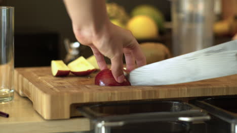 cerca de manos femeninas cortando una manzana roja