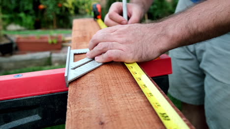 carpenter prepares wood for woodworking project, slow motion of hands making measurements on wood plank