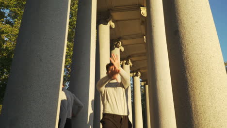 young group dancing choreography between tall columns