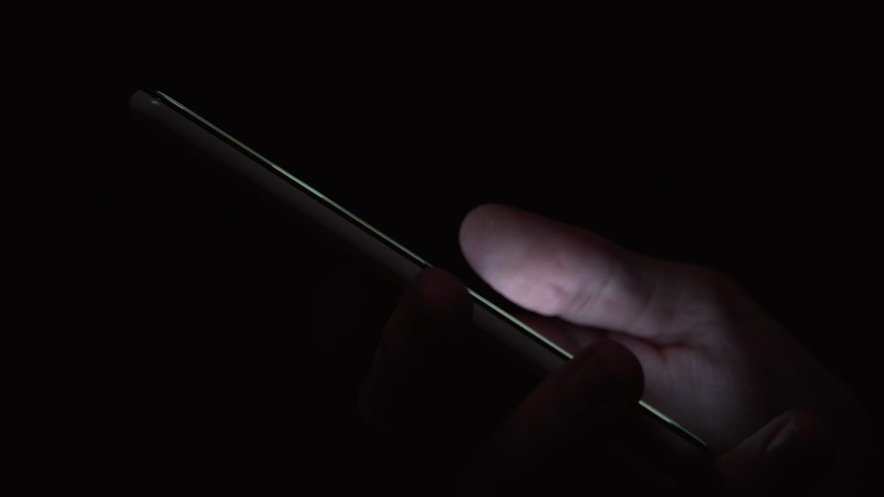 reflejo de la pantalla en el ojo verde azul de la persona en una habitación oscura 14