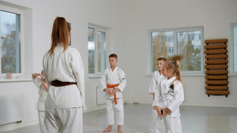 kids in white kimono and teacher in martial arts class