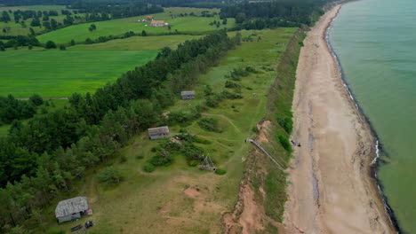cabañas o bungalows a lo largo de los acantilados en la orilla del mar de jurkalne, letonia - revisión aérea creciente