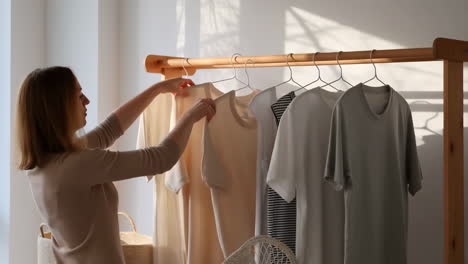 woman arranging clothes on a rack