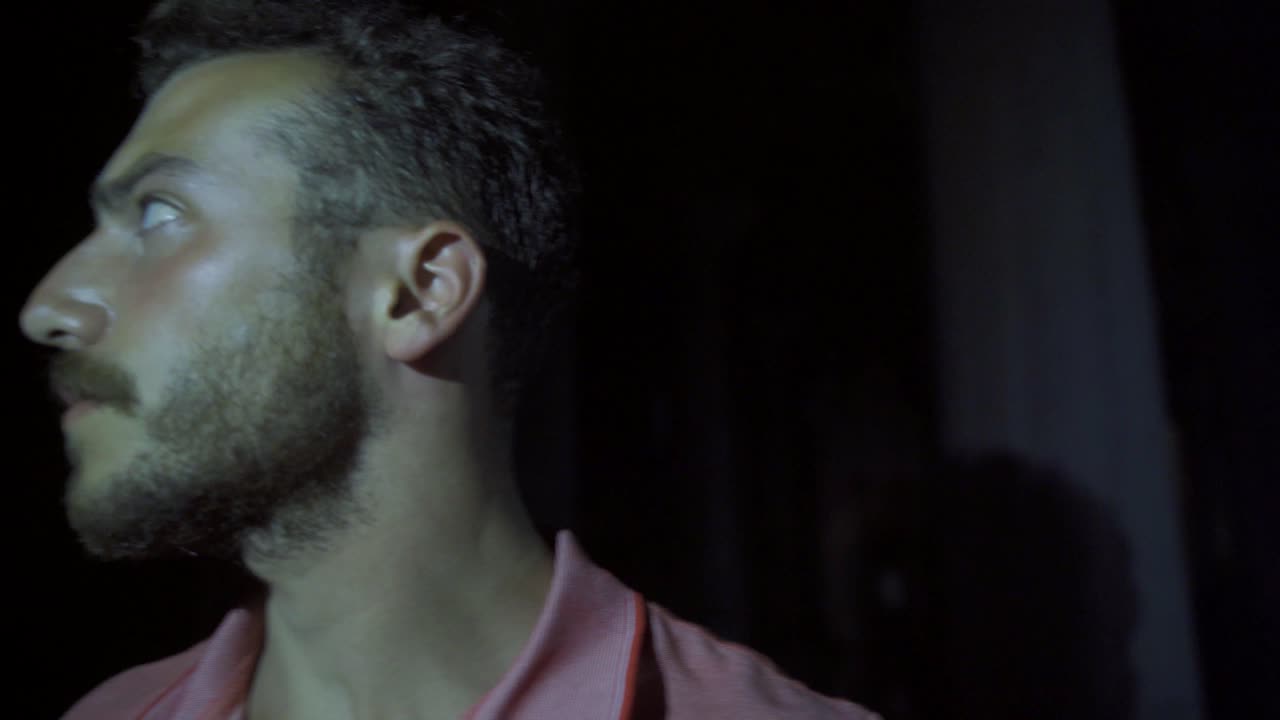 hombre nervioso en un lugar oscuro.