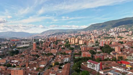 Cinematic-Medellin-city-skyline-in-Colombia-during-sunrise,-aerial-sideways