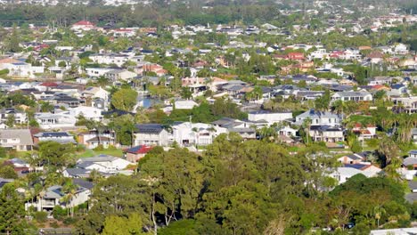 aerial view of suburban landscape with lush greenery and residential buildings under bright daylight