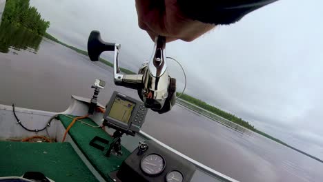 Behind-close-shot-of-spinning-fishing-reel-while-fishing-for-walleye-in-The-Whiteshell-Provincial-Park,-Point-du-Bois-near-Winnipeg-Manitoba-Canada