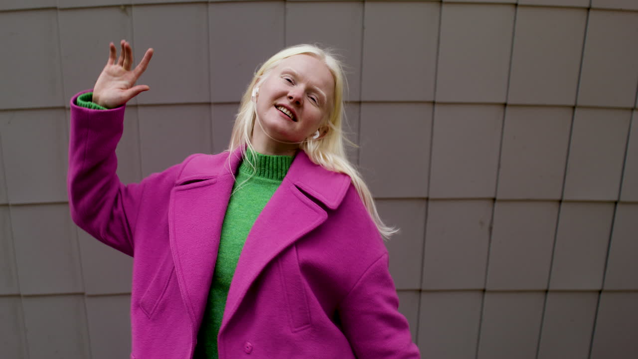 улыбающаяся женщина, использующая наушники на улице