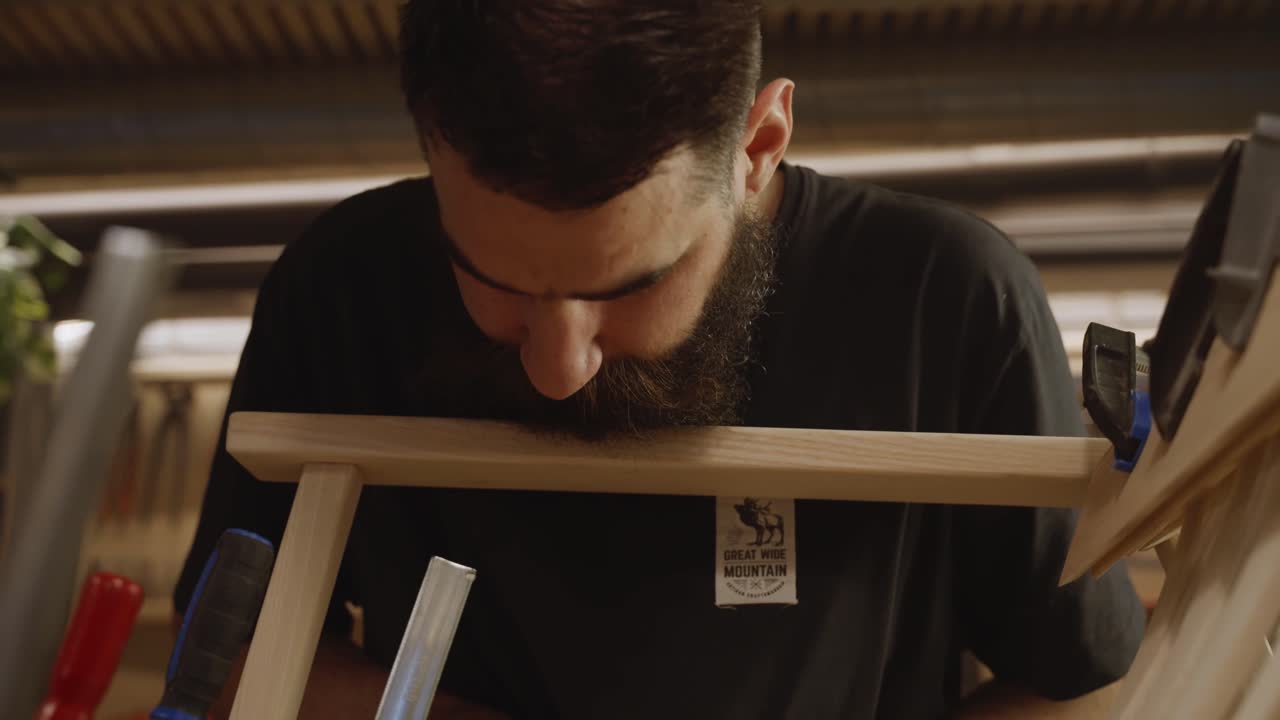 Close-up view of a craftsman precisely measuring a wooden frame using a ruler and pencil, highlighting woodworking accuracy, craftsmanship, and attention to detail in furniture making