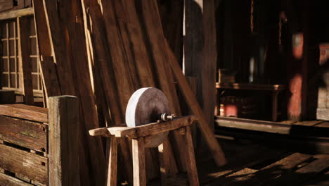 a wooden grinding wheel surrounded by rustic wooden planks in an old workshop