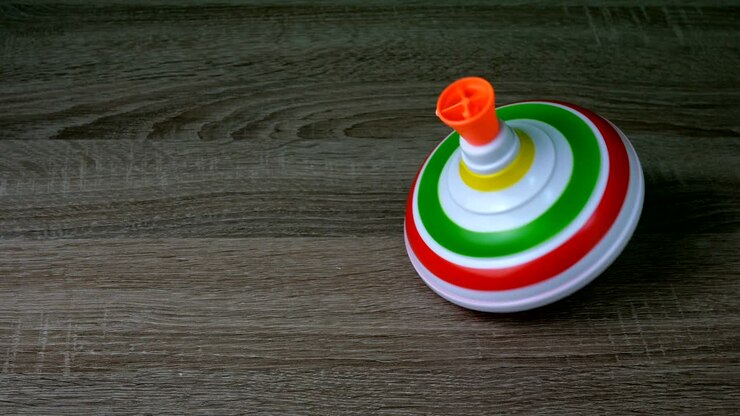 Multicolored plastic spinning top or whirligig top is traditional toy for preschool child.