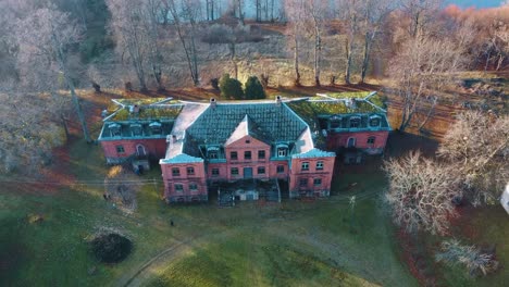 old red brick house, katvari manor in latvia and katvaru lake in the background