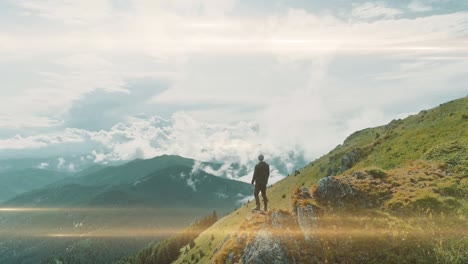 the young man is standing on the mountain edge