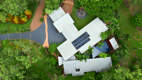 aerial drone of rural prestigous tropical style home with solar panels top down descend