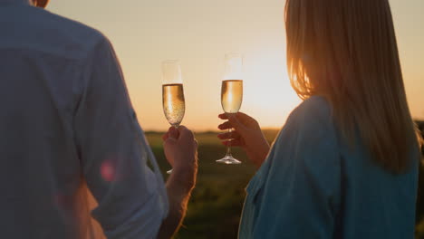 happy couple with glasses of red wine watching the sunset over a picturesque valley. 4k video