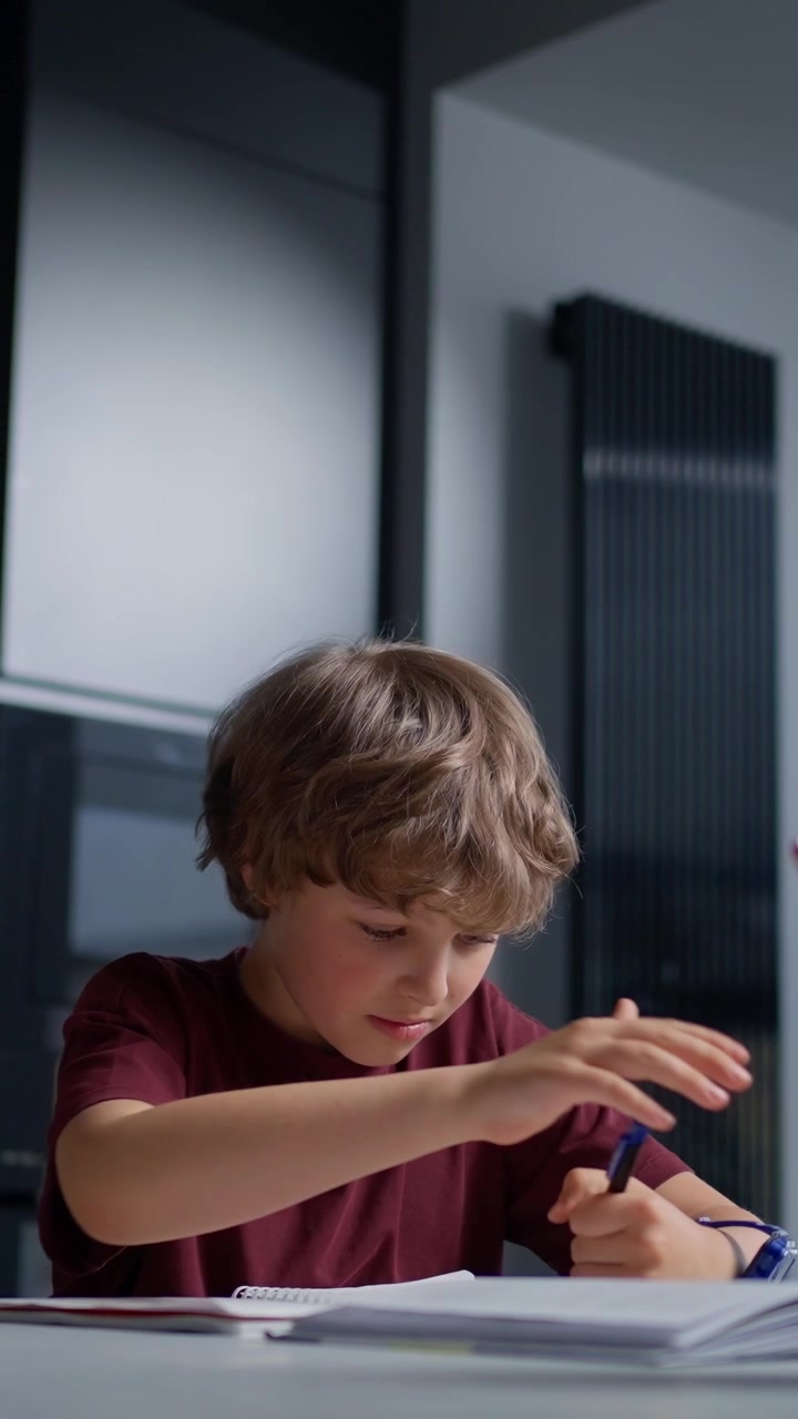 Un ragazzino che si concentra a scrivere in un quaderno