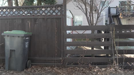 Alley-with-garbage-bin-next-in-a-fence