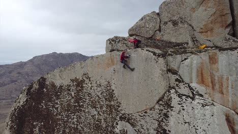 rock climber drilling a hole in a rock with an electrical driller