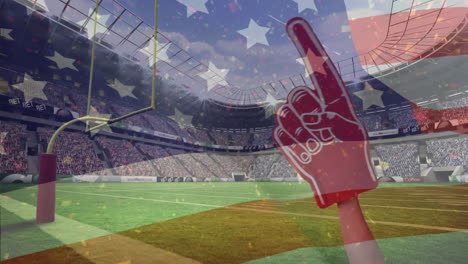 american football fan with red foam finger supports team, american flag waves in full stadium.