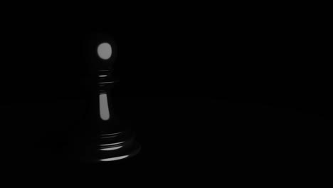 peón brillante negro sobre un fondo oscuro