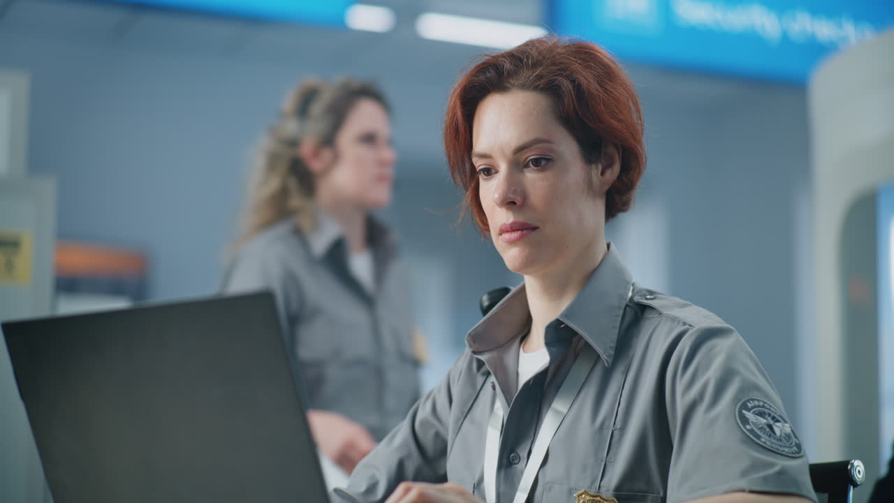 oficial de seguridad del aeropuerto trabajando en una computadora portátil