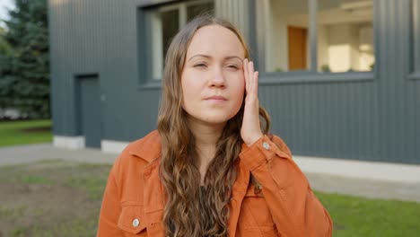 woman stops to think, raises hand to temple side of head jogging memory