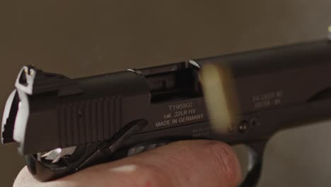 pistol being fired in slow motion and shell casing flying out