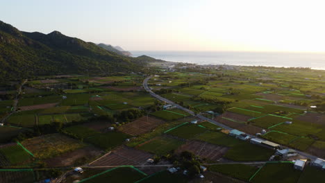 Hermosa-Puesta-De-Sol-En-La-Playa-Y-Campos-Verdes-Del-Campo-De-Nui-Chua,-Vietnam---Toma-Aérea