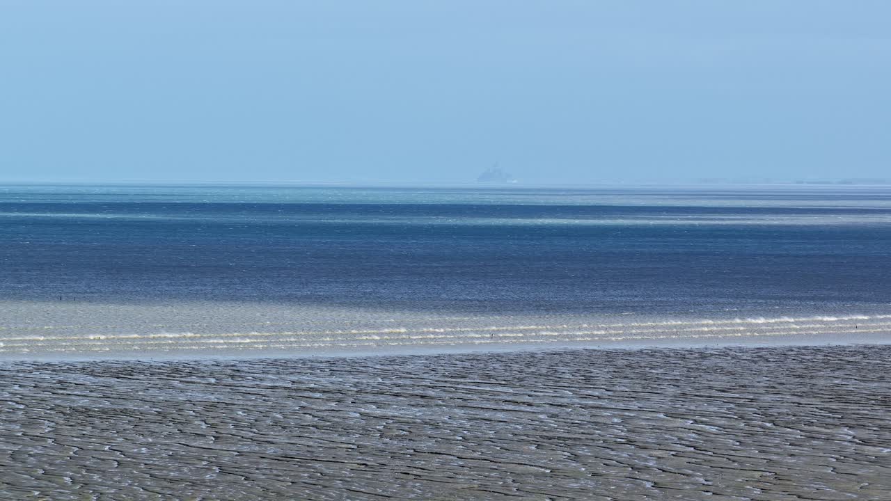 Vista aerea panoramica del Mare del Nord e della sabbia grigio scuro di una spiaggia francese con la bassa marea.