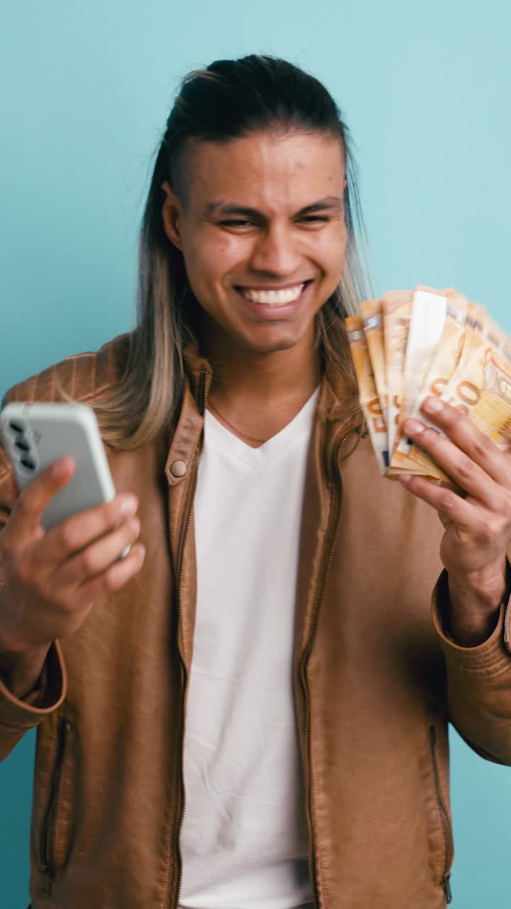 Joven feliz sosteniendo un smartphone y billetes de euro