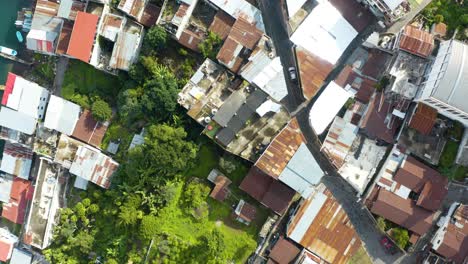 Bird's-eye-view-of-winding-mountain-road-cutting-across-coastal-homes-in-Lake-Atitlan-Guatemala