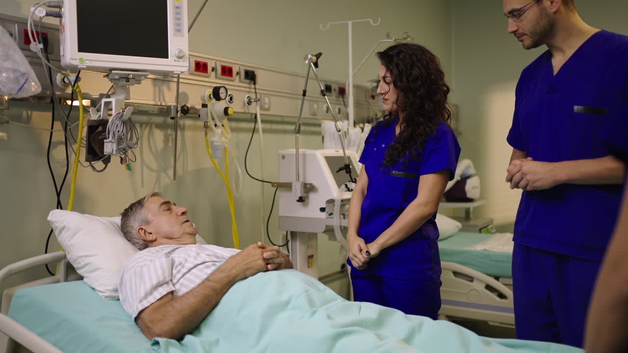Medical staff attending to a patient in a hospital bed