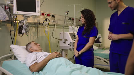 medical staff attending to a patient in a hospital bed