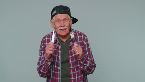anciano anciano hambriento esperando para servir la cena platos con cubiertos, apreciará una deliciosa comida