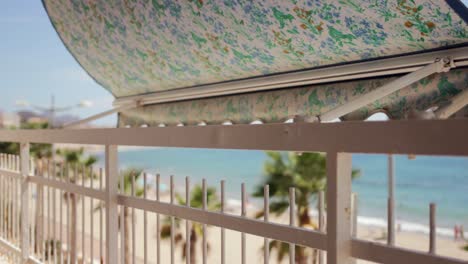 view from balcony to mediterranean beach with palm trees