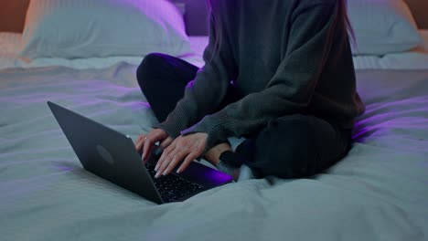 mujer trabajando en la computadora portátil en la cama por la noche