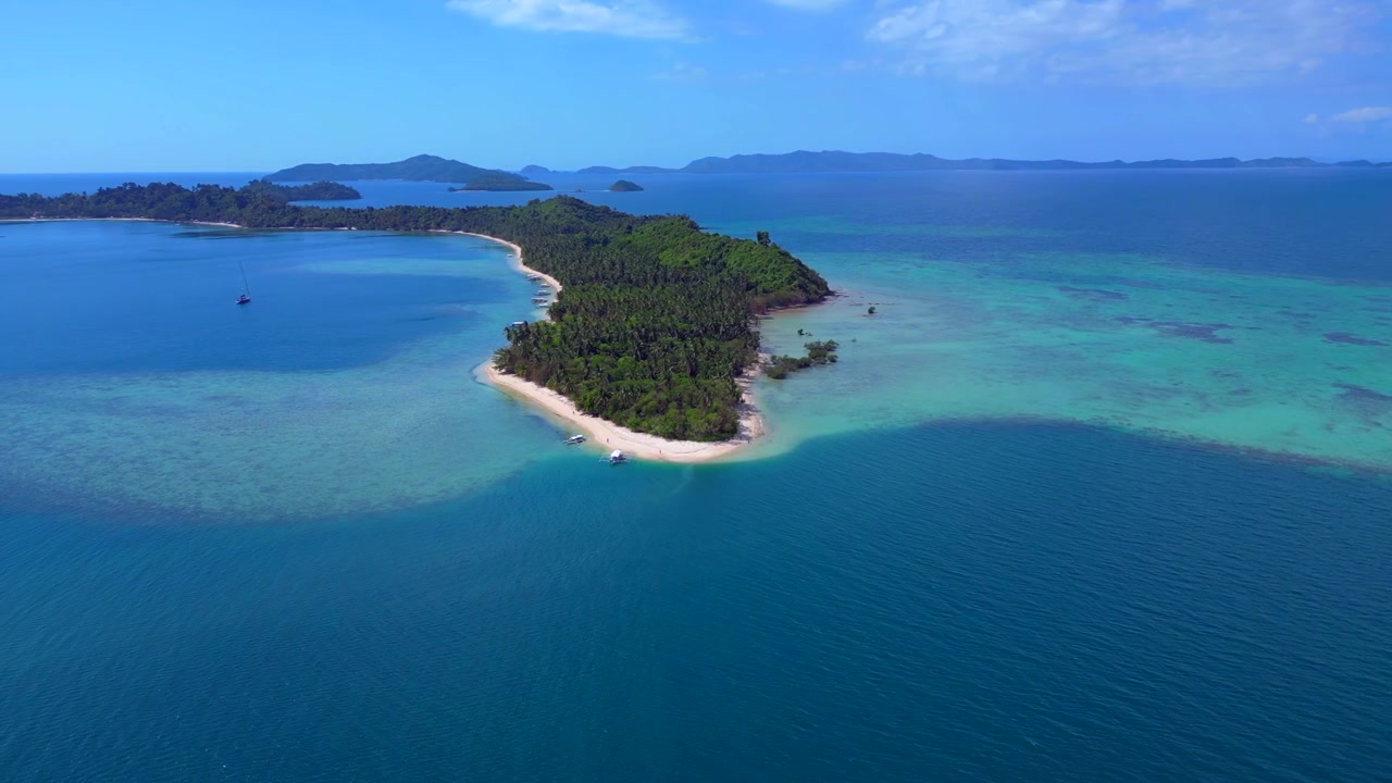 鮮やかな緑のヤシの木、手つかずの白い砂浜、透き通った海の水が広がるカプサライ熱帯の島。広範囲を周回するドローンからの素晴らしいパノラマ空撮。