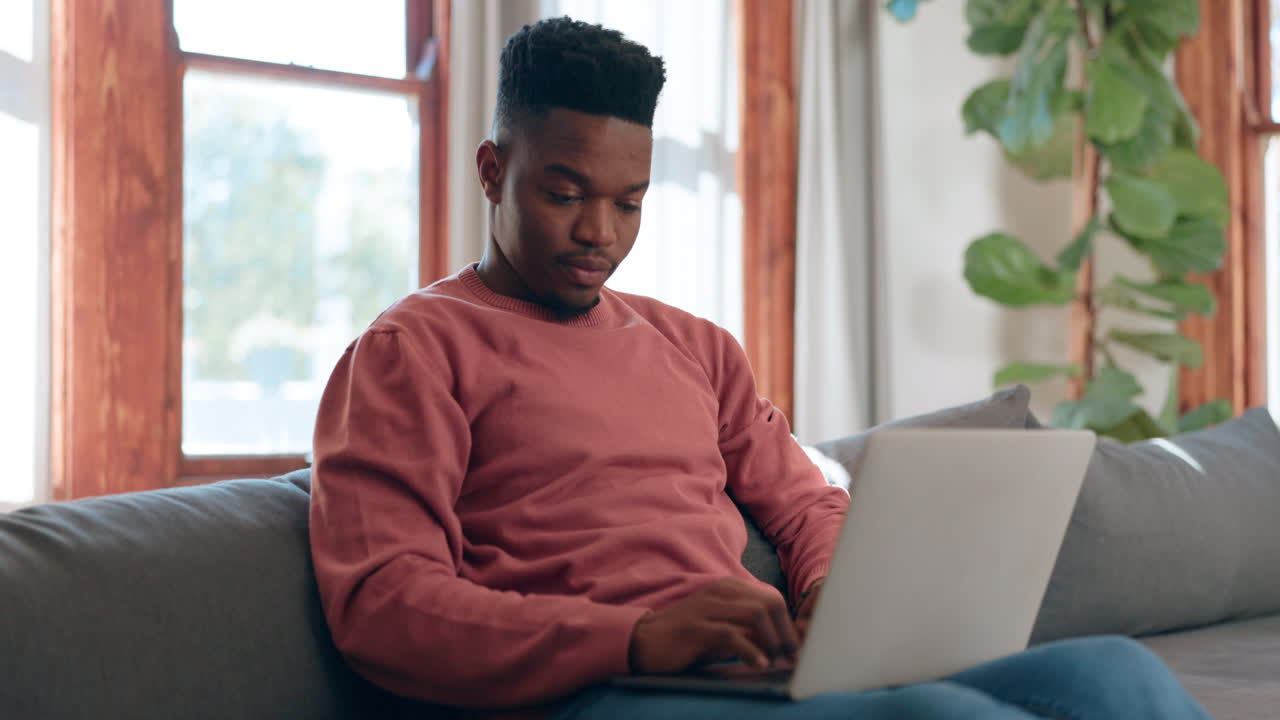 Man, reading and typing on laptop in home