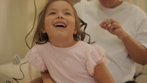 madre embarazada peinando el cabello de su hija en casa