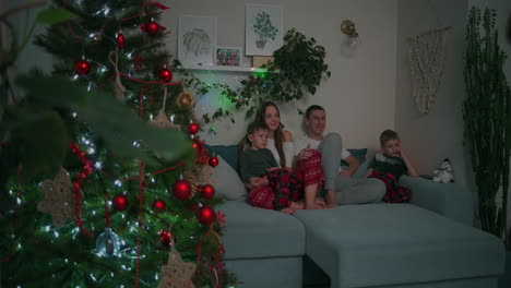 Vínculo-Familiar-En-Navidad.-Juntos-En-Un-Sofá-Y-Viendo-Televisión-En-Casa-Durante-Las-Vacaciones-De-Navidad.-Imágenes-4k-De-Alta-Calidad