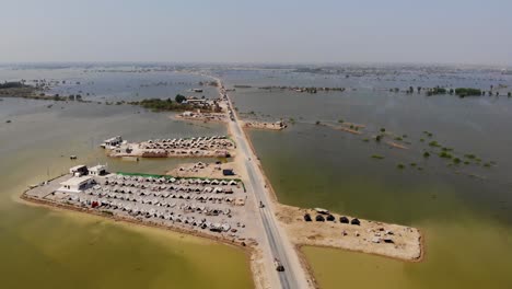 辛德邦鄉村雅各巴德 (jacobabad) 的孤獨高架公路與土地住房,被龐大洪水包圍的洪水難民臨時營地