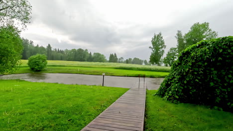 Heavy-rain-over-rural-countryside-landscape-with-pathway,-static-view