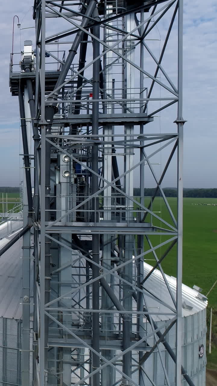 Silos big industrial factory containers. Modern huge metal constructions. Aerial view. Vertical video